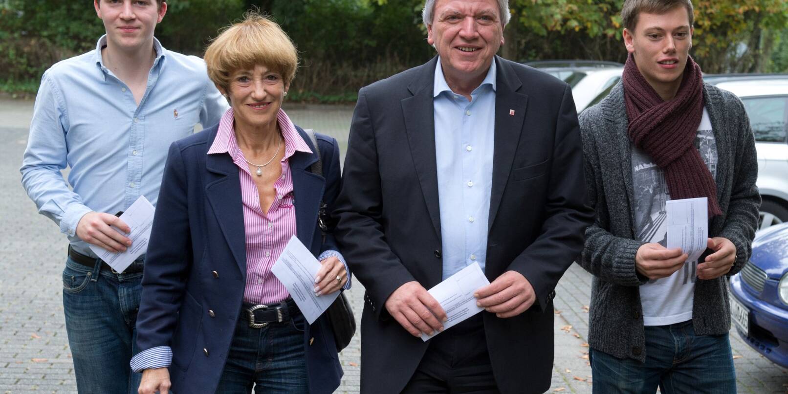 Volker Bouffier (CDU, 3vl) geht zu einem Wahllokal, um dort seine Stimme für die Landtagswahl abzugeben. Neben ihm geht seine Ehefrau Ursula, rechts Sohn Volker, links sein Sohn Frederik.