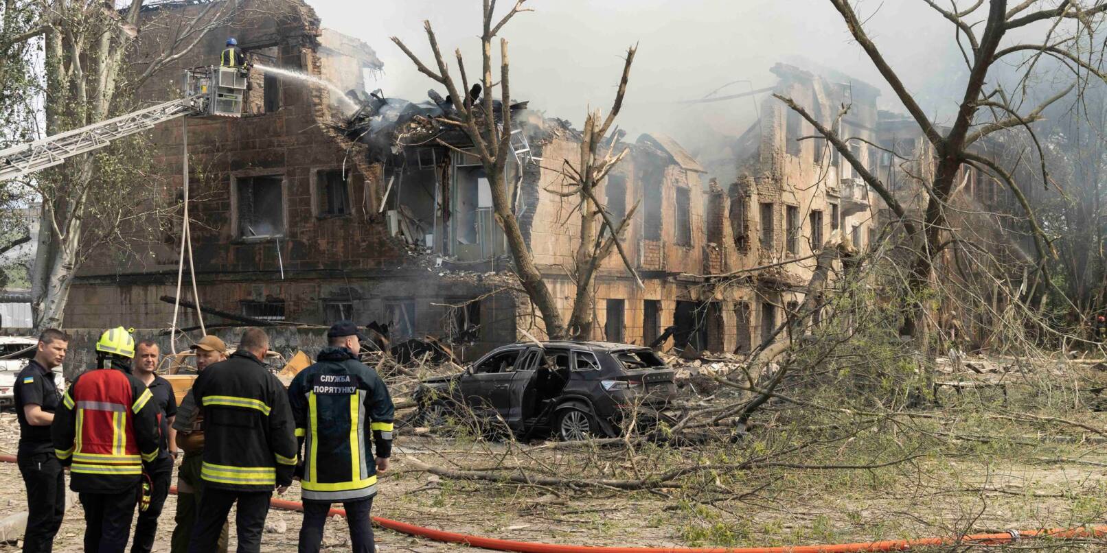 Feuerwehrleute und Rettungskräfte in der Nähe der völlig zestörten Klinik in Dnipro.